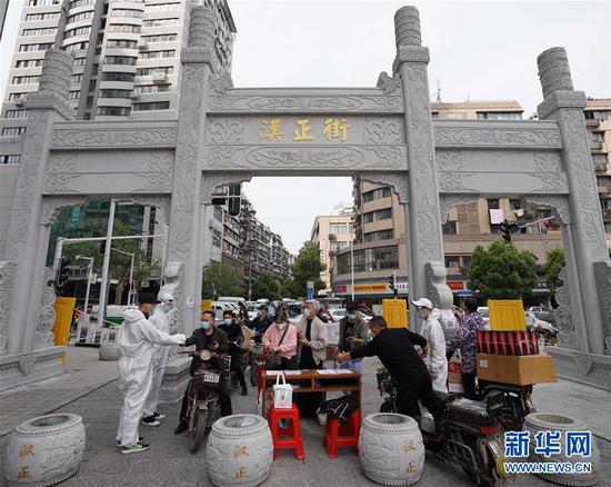  4月16日，進(jìn)出武漢漢正街步行街的人員在掃描健康碼。新華社記者 王毓國(guó) 攝